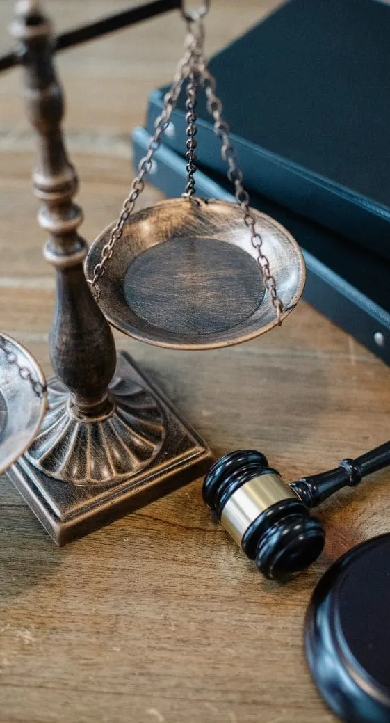 Scales of justice and a gavel in front of law books